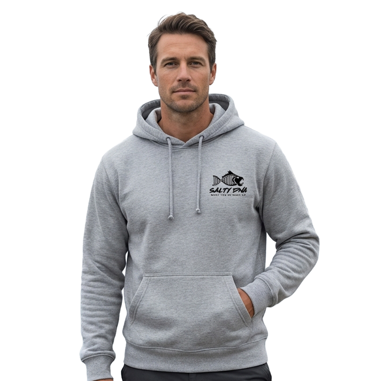 Man wearing a grey Salty DNA hoodie by the water